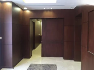 نجار في جدة يقوم بتركيب باب سحاب خشبي جرار في غرفة معيشة